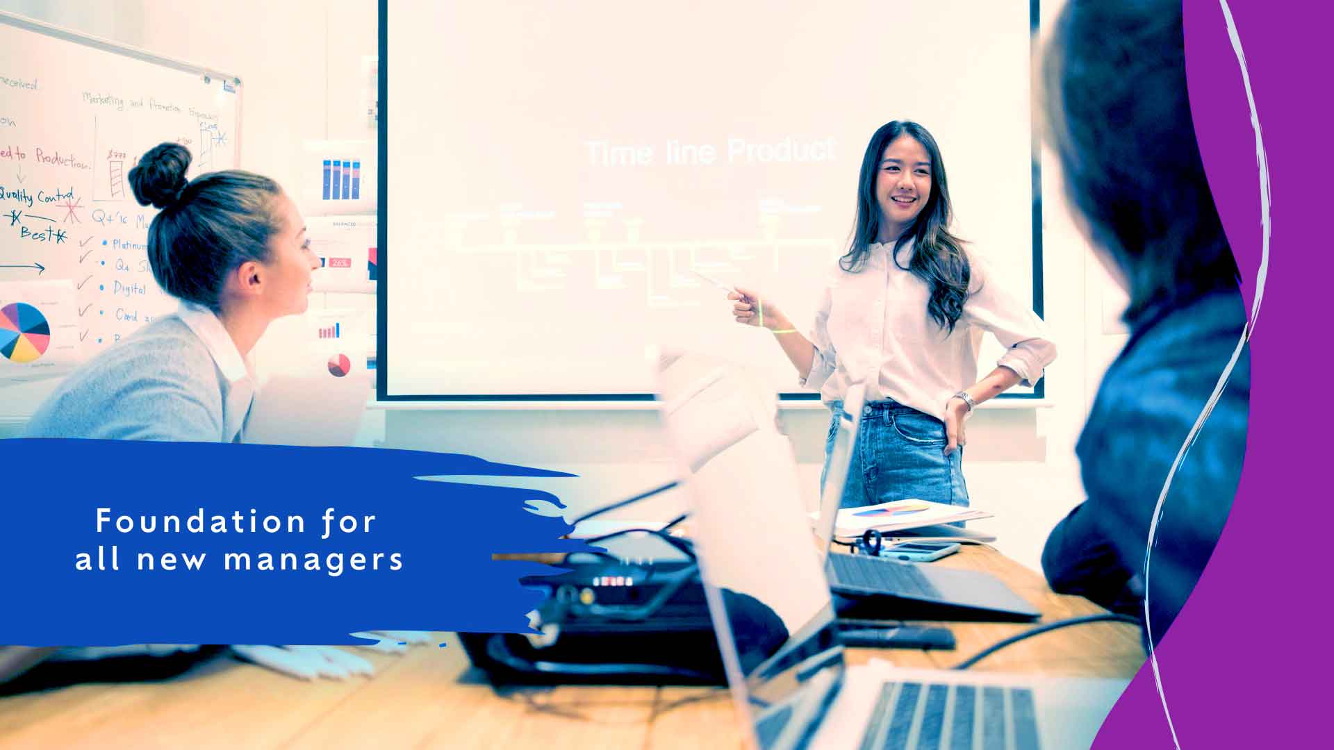 People working together in a conference room with a whiteboard and laptops.