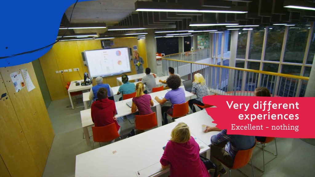 A group of people in a classroom setting listening to a presentation.